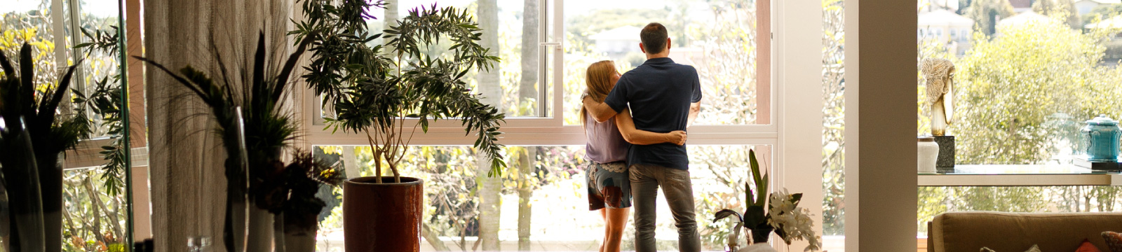 A couple standing in front of window in home