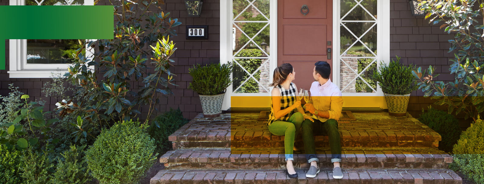 A young couple sitting on front patio of home