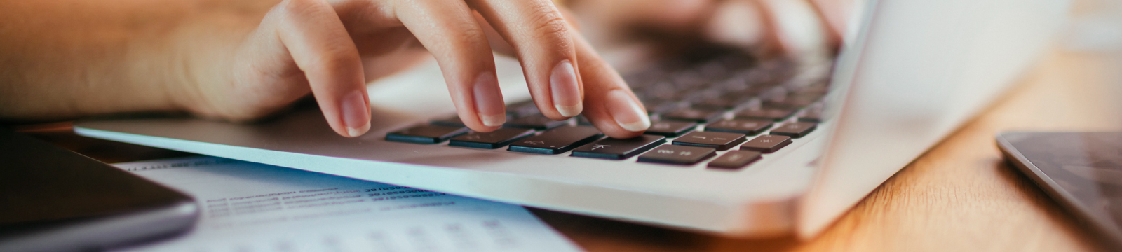 Hands typing on a keyboard of a laptop