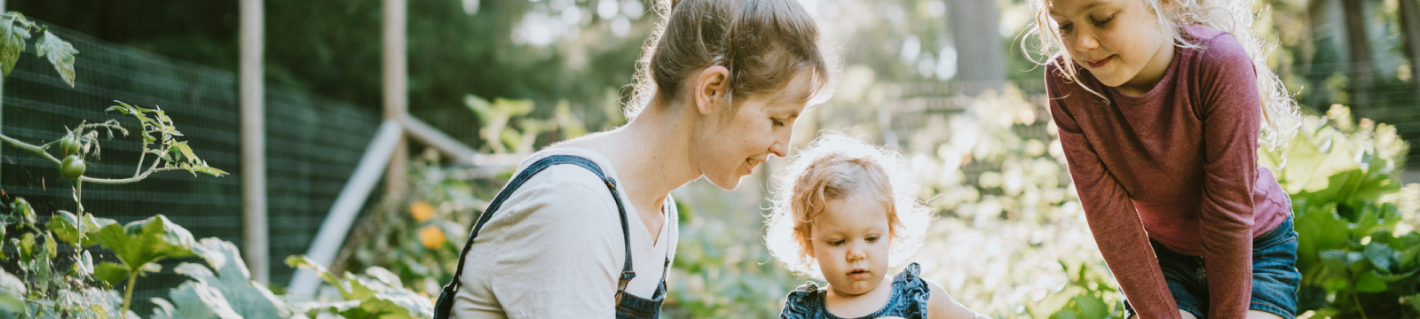 A mother and two daughters outside in a garden