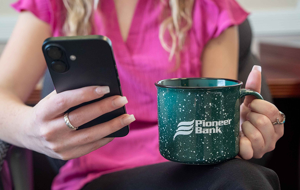 Customer holding Pioneer Bank coffee cup