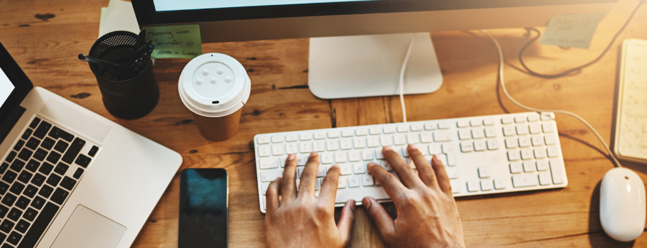 Hands on desk typing on a keyboard